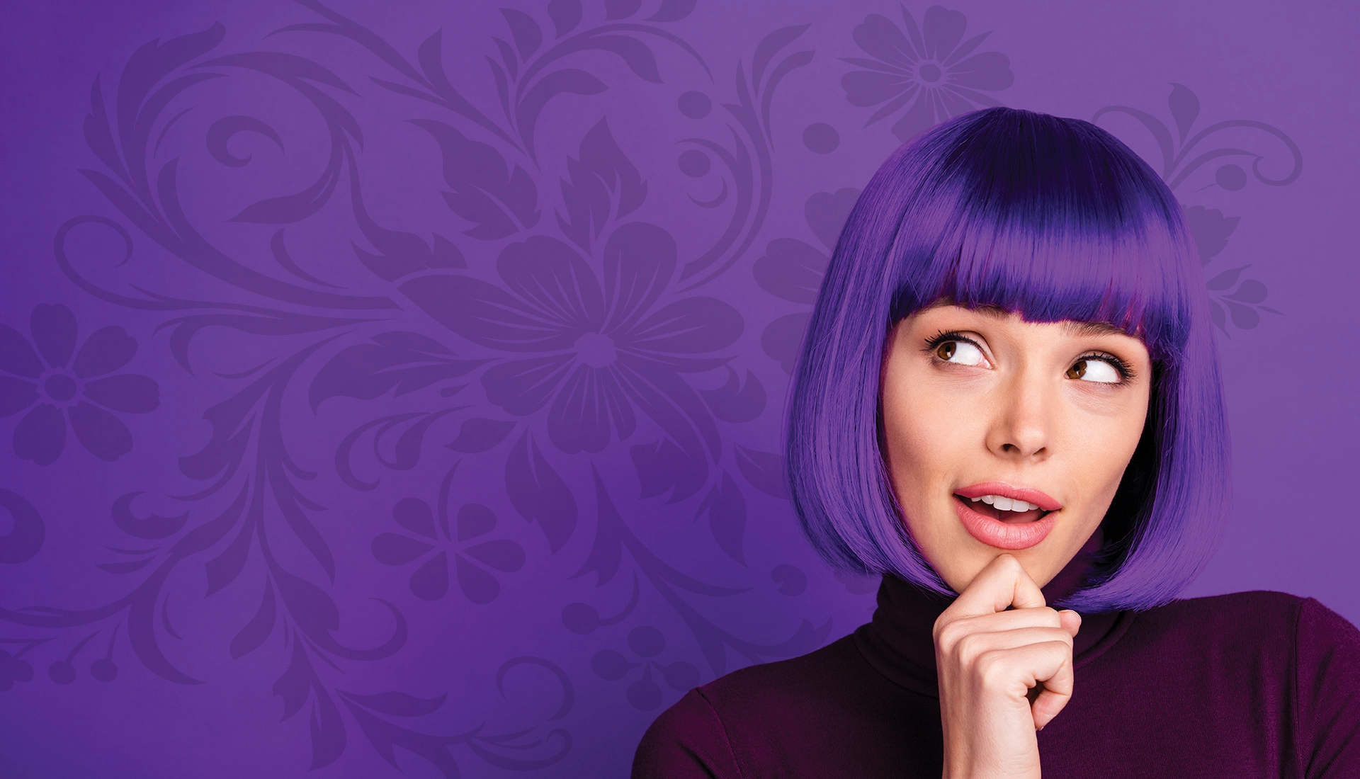 Portrait of a woman with bright purple hair and pink lipstick, looking to the side against a purple floral-patterned backdrop.